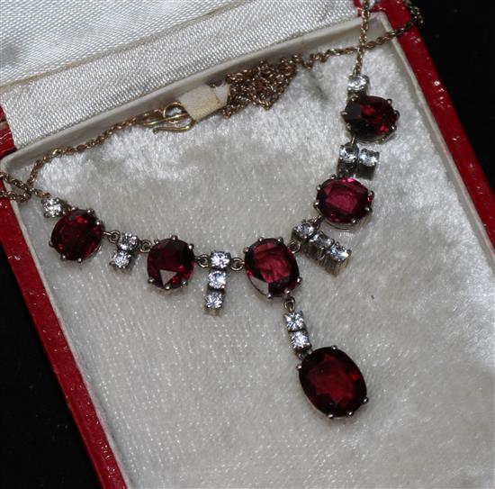 A garnet and white stone pendant necklace.